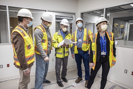 A group of people wearing yellow vests and hard hats tours the Pavilion: Michael Beauchamp, PhD, professor and vice chair of Neurosurgery; Daniel Yoshor, MD, chair of Neurosurgery; Stephen Greulich, senior vice president for large capital projects; Brian Litt, MD, PhD, professor of Bioengineering and Neurology, and Kathryn Davis, MD, assistant professor of Neurology